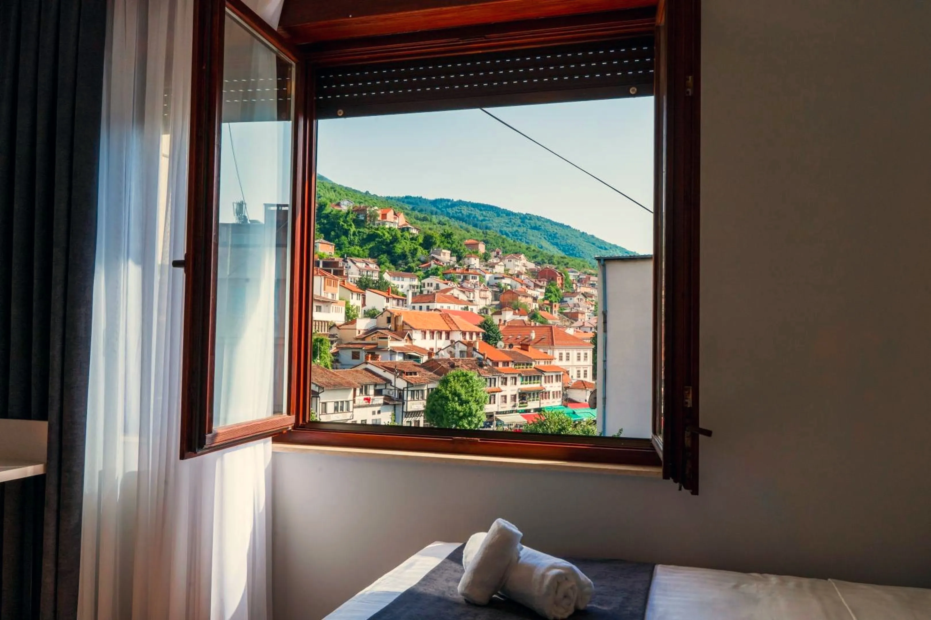 The window view over the rooftops of Prizren to the hills