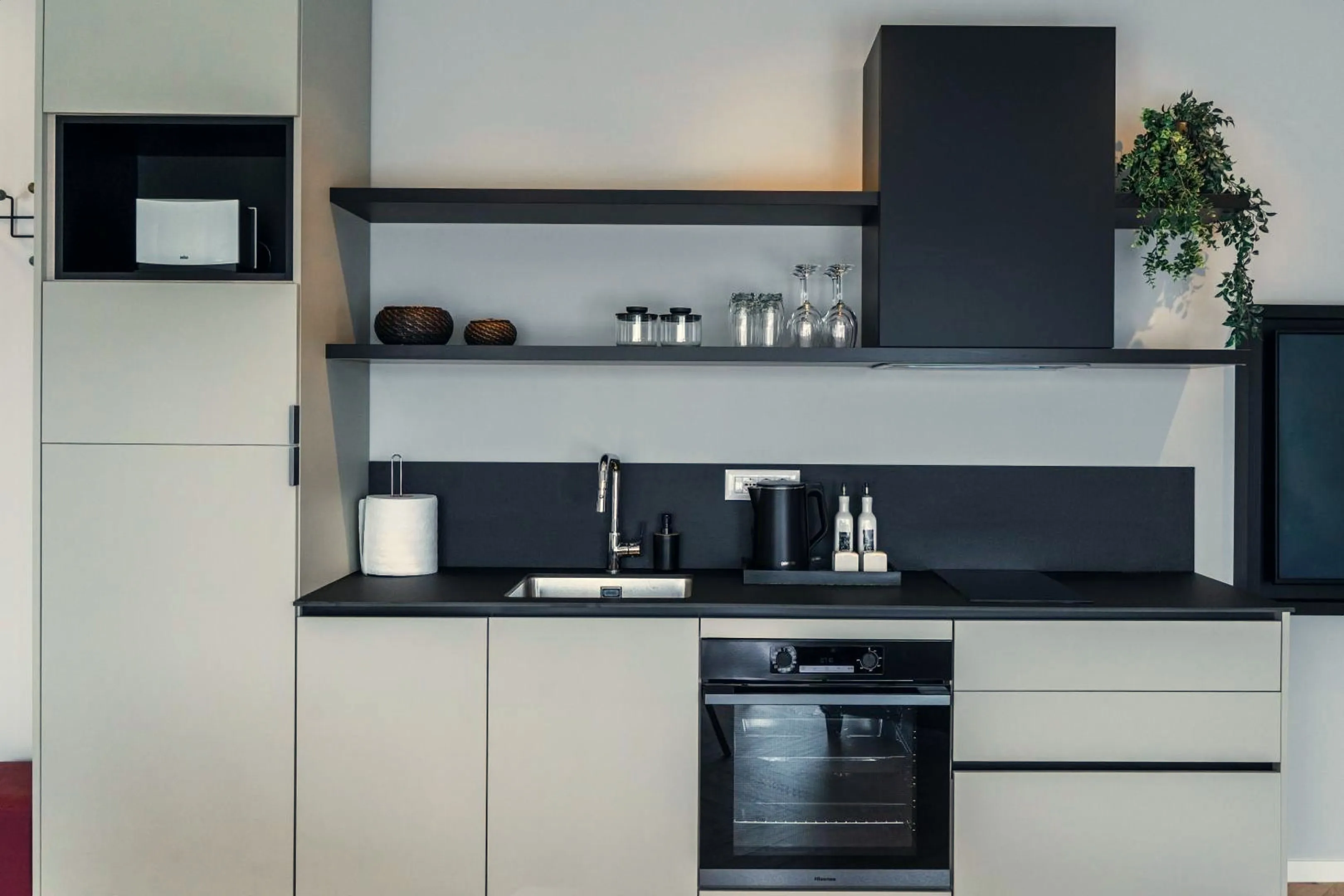 The kitchen with a black splashback and open shelves