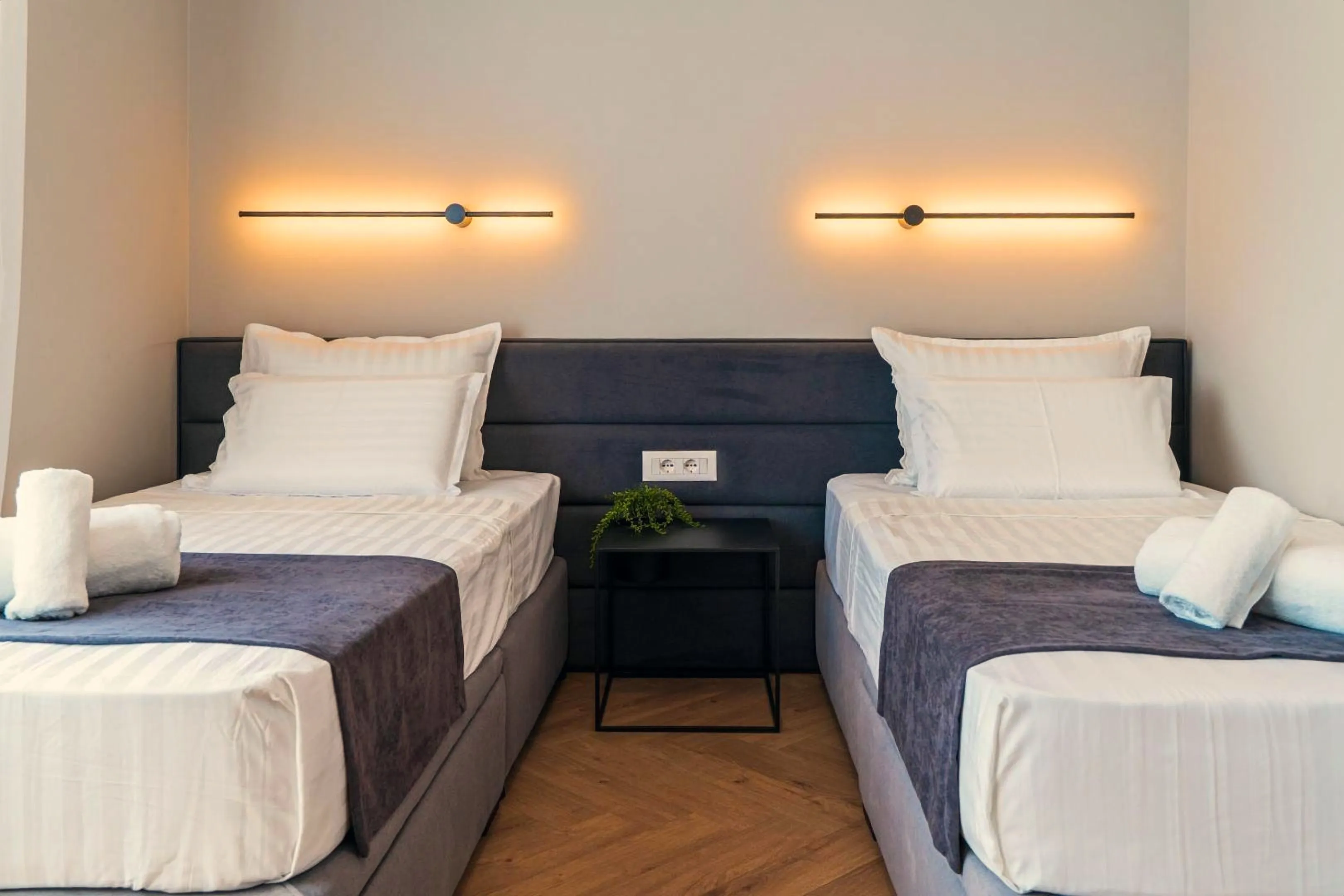 The twin bedroom with two beds and wall lights